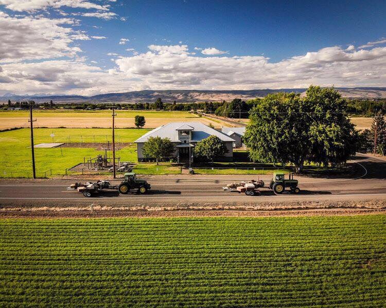 Arial photo of Damman School building showing tractors on road in front of school. 